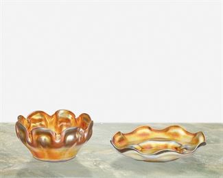 72
A L.C. Tiffany Favrile Glass Finger Bowl And Ice Plate
First-quarter 20th Century; New York, NY
Bowl signed: L.C.T.; Ice plate signed: L.C.T. / Favrile
Each gold iridescent with scalloped edge, comprising a bowl with ribbon-style edge and an ice plate, 2 pieces
Bowl: 2.25" H x 4.5" Dia.; Ice plate: 1.25" H x 6" Dia.
Estimate: $400 - $600
