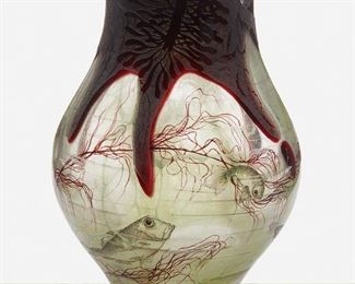 74
A Daum "Algues Et Poissons" Intercalaire Glass Vase
Circa 1898; Nancy, France
Etched signature to underside: Daum Nancy [Croix de Lorraine]
Designed by Henri Berge, the rotund intercalaire vase with layers of blue and green glass cased in acid-etched burgundy glass depicting a painted polychrome enamel seascape of algae, a hermit crab, and fish motifs
7.25" H x 5.25" Dia.
Estimate: $1,000 - $1,500
