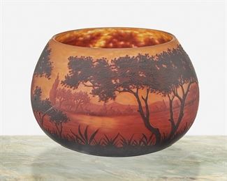 82
A Daum Cameo Glass "Paysage Du Lac" Bowl
First-quarter 20th Century; Nancy, France
Signed: Daum Nancy [Croix de Lorraine]
The acid-etched cameo glass bowl cut from dark red and red to orange frost with wooded lakeside motif
5.5" H x 8" Dia.
Estimate: $1,000 - $1,500