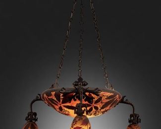 93
A Daum Cameo Glass "Wilder Wein" Chandelier
First-quarter 20th Century; Nancy, France
Signed: Daum Nancy [Croix de Lorraine]
The acid-etched cameo glass domical "Wilder Wein" shade with wild vines and berry motifs cut from brown to red and yellow mottled frost, fitted with two light sockets and three drop pendants with matching shades, mounted with wrought iron hardware, canopy, and suspended chain link harness, electrified
33" H x 23" Dia.
Estimate: $3,000 - $5,000