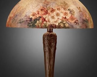 107
A Handel Reverse-Painted Glass "Rose Blossom" Table Lamp
Circa 1919; Meriden, Connecticut
Shade signed: Handel Lamps / Pat'd. No. 979664 / Handel / 6688; Base signed: Handel [cloth label] / Handel [incised mark]
The domical, chipped ice finished glass shade with reverse-painted polychrome rose blossom and butterfly motifs on a three-light patinated metal tapered base with low relief trees and roots extending over a circular foot, electrified
Overall: 23" H x 18" Dia.
Estimate: $2,000 - $3,000