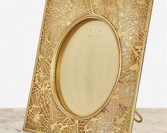 140
A Tiffany Studios Gilt-Bronze Pine Needle Frame
Circa 1902-1919; New York, NY
Signed: Tiffany Studios / New York / 919
The rectangular gilt-bronze frame with white and amber mottled glass, pine needle motif gilt-bronze overlay, and beaded border enclosing an oval opening
Overall: 11.75" H x 9.5" W x 6.5" D; Opening: 8" H x 6" W
Estimate: $1,500 - $2,000
