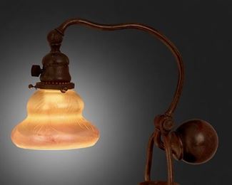 146
A Tiffany Studios Counter-Balance Desk Lamp
Circa 1902-1919; New York, NY
Shade signed: L.C.T.; Base signed: Tiffany Studios / New York / L 1421
The gold iridescent Favrile glass shade with pulled feather motif on a patinated bronze counter-balance "Chaflin" base with curved stem, weighted ball, and adjustable head, electrified
Base: 14" H x 5.25" W x 5.75" D; Shade: 5.25" Dia.
Estimate: $1,000 - $1,500