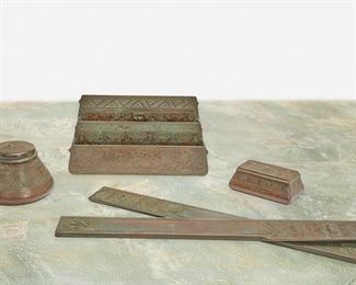 151
A Tiffany Studios "American Indian" Desk Set
Circa 1902-1919; New York, NY
Each signed: Tiffany Studios / New York; Further marked: 1181 / 1183 / 1184 / 1186
Each verdigris patinated bronze with Native American-style motifs and geometric designs, comprising a paper rack, an inkwell, two large blotter ends, and a stamp box, 5 pieces
Largest: 5.75" H x 11" W x 2.75" D; Smallest: 1.75" H x 5" W x 3" D
Estimate: $800 - $1,200