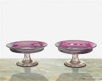 155
A Near-Pair Of Tiffany & Co. Amethyst Glass Compotes
1907-1947, directorship of John C. Moore II
Marked: Tiffany & Co. / 19609 Makers 4623 / Sterling Silver / 925-1000 / M
Each amethyst glass compote with fluted design raised on a sterling silver circular foot, 2 pieces
Larger: 3.75" H x 6.625" Dia.
Estimate: $600 - $800