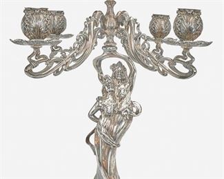 171
An American Art Nouveau Silver Plate Candelabrum
Late 19th/early 20th Century
Marked for E.G. Webster & Son; Further marked: 3305
The silver plate candelabrum with figural column issuing four swirling arms and one central arm, each terminating in cabbage-leaf motif capitals and bobeches
20" H x 18" W x 18" D
Estimate: $500 - $700