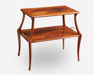174
A Louis Majorelle Two-Tiered "Au Gui L'an Neuf" Table
Late 19th/early 20th Century; Nancy, France
Singed in marquetry: L. Majorelle
The rectangular two-tiered table with fixed top held aloft by four carved supports over a widening undershelf with stationary gilt-bronze handles, each tier with mistletoe motif marquetry and the upper tier with marquetry text reading "au gui l'an neuf," raised overall on four slightly flared carved legs, the upper tier with fitted glass top
31.5" H x 33.5" W x 22" D
Estimate: $2,500 - $3,500