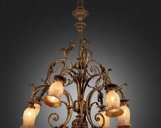188
A Rococo-Style Gilt-Bronze Chandelier With Quezal Art Glass Shades
First-quarter 20th Century
Each shade signed: Quezal
The six-light gilt-bronze chandelier with central knopped column, gadrooned canopy, openwork fonts, pointed finial, and scrolling foliage issuing six arms terminating in white and gold Quezal spun glass shades with green leaf motif, electrified
39" H x 36" Dia.
Estimate: $1,000 - $1,500