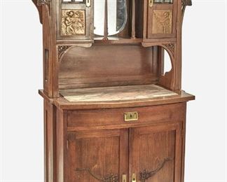 190
An Art Nouveau Walnut Curio Cabinet
Late 19th/early 20th Century
The walnut curio cabinet with glazed doors featuring beveled leaded glass and opposed figural repousse gilt-copper inset panels, each concealing a fitted interior with single adjustable shelf, flanking an open tiered center gallery with beveled glass backing, foliate shelf supports, and floral gallery rails over a bow-front console with pink and white inset marble top over one central drawer, two doors with carved floral motif, and fitted interior with one shelf compartment
76" H x 41" W x 21" D
Estimate: $1,000 - $1,500