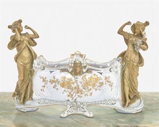 213
An Austrian Jugendstil Ceramic Centerpiece
Late 19th/early 20th Century; Austria
Marked: Made in Austria / 4635 / 223 / 5
The ovoid ceramic centerpiece with gilt-highlight floral sprays surmounted by figural masks, flanked by two standing female figures, and raised on two central feet
12.5" H x 18" W x 7.25" D
Estimate: $600 - $800