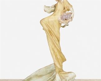 214
An Amphora "Dancing Lady With Flowers" Vide Poche
Late 19th/early 20th Century
Marked: Amphora / Riessner, Stellmacher & Kessel [RStK] Turn-Teplitz Bohemia / Made in Austria / 777 / 4
The ceramic vide poche with a low dish base and depicting a dancing woman in a yellow dress with a purple morning glory flower and gilt highlights throughout
16" H x 7.75" W x 9.5" D
Estimate: $500 - $700