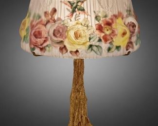 218
A Pairpoint Reverse-Painted Puffy Glass "Devonshire" Table Lamp
1907-1929; New Bedford, Massachusetts
Shade: unsiged; Base signed: Pairpoint Mf'g. Co. ["P" diamond monogram] / 3091
The mold-blown puffy and frosted glass "Devonshire" shade with reverse-painted polychrome roses and hummingbirds against opaque white stripes and torch and wreath motif on a single-light gilt-bronze tree trunk base with circular foot, electrified
Overall: 23" H x 15.5" Dia.
Estimate: $2,000 - $3,000