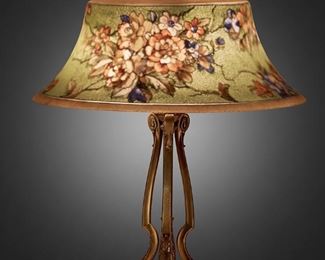 219
A Pairpoint Reverse-Painted Glass "Exeter" Table Lamp
1907-1929; New Bedford, Massachusetts
Shade signed: The Pairpoint Corp.; Base signed: Pairpoint ["P" diamond monogram] / D 3084 <br /> <br /> <br /> <br /> <br /> <br /> <br /> <br /> <br /> <br /> <br /> <br />
The bell-form frosted glass "Exeter" shade with reverse-painted polychrome floral motif against a green ground with yellow borders on a three-light brass tripod base with three scrolled supports raised on a triform foot, electrified
Overall: 21" H x 17" Dia.
Estimate: $1,000 - $1,500