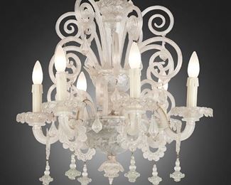 229
A Venetian Murano Glass Chandelier
First-quarter 20th Century; Venice, Italy
The clear Murano glass chandelier with stepped column, wave-form designs throughout, and leaf motif to upper gallery, issuing five ogee arms with bobeches terminating in candle sleeve lights and eighteen scrolled branches, with floral and teardrop pendalogues, electrified
25" H x 21" Dia.
Estimate: $800 - $1,200