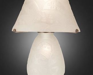230
A Daum Art Deco Etched Glass Table Lamp
Second-quarter 20th Century; Nancy, France
Base and shade signed: Daum Nancy / France [Croix de Lorraine]
The acid-etched clear glass table lamp with frosted geometric square and wave-form designs throughout, the domical shade with scalloped border atop a bulbous base with Edgar Brandt hammered metal hardware, electrified
Overall: 18" H x 13" Dia.
Estimate: $2,000 - $3,000