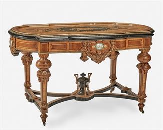 256
A Victorian Renaissance Revival Marquetry Library Table
Third-quarter 19th Century
The gilt-bronze mounted library table with musical motif marquetry to top with squared corners, rounded sides, gilt-highlight trim, and ebonized wood molding over a carved apron with applied painted porcelain plaques and foliate swags supported by four carved tapered legs with incised gilt highlights joined by an X-stretcher with buttressed urn and raised overall on castors
31" H x 55" W x 33.5" D
Estimate: $2,000 - $3,000