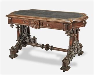258
A Victorian Renaissance Revival Library Table
Third-quarter 19th Century
The mahogany library table with squared corners, rounded sides, and inset black leather writing surface with gold foil acanthus leaf border over a single divided frieze drawer with carved key frame, supported by openwork carved and turned trestle-style legs joined by a turned stretcher raised overall on four block pedestal feet with castors
29" H x 51" W x 29" D
Estimate: $1,000 - $1,500