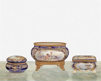 265
A Group Of French Sèvres-Style Porcelain Items
Second-half 19th Century
Each variously marked
Each with gilt-highlight scrolled foliate motif against cobalt blue ground, comprising a small footed jardiniere with central pastoral figural scene mounted with gilt-bronze beaded rim and four flared feet, a rectangular hinged dresser box with figural and landscape scenes, and a circular hinged dresser box with figural scene to lid, 3 pieces
Largest: 6.5" H x 9.5" W x 6" D; Smallest: 4" H x 5.75" Dia.
Estimate: $1,000 - $1,500