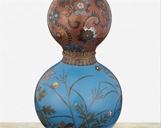 280
A Chinese Double-Gourd Cloisonné Vase
Second-quarter 20th Century
The detachable double-gourd cloisonne vase with polychrome scrolling foliate motif against a brick-red ground to the top and polychrome floral and butterfly motifs against a blue ground to the bottom with gilt-metal beaded band to the center
9" H x 5" Dia.
Estimate: $500 - $700