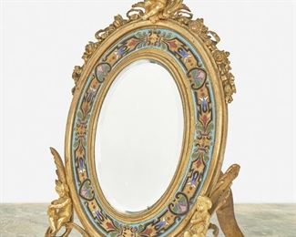 288
An Alphonse Tahan Cloisonné Enamel And Gilt-Bronze Table Mirror
Third-quarter 19th Century; Paris, France
Signed: Tahan / Fournisseur de L'Empereur
The oval easel-back gilt-bronze frame with floral garlands and putti surrounding a cloisonne enameled border and enclosing an oval glass mirror
10" H x 7.25" W x 5.5" D
Estimate: $800 - $1,200