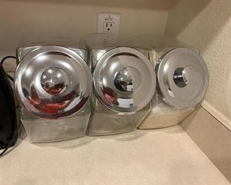 $38~ Set of three chrome top canisters