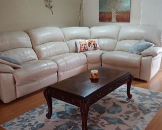 Leather Sectional with Recliners, Area Rug & Coffee Table. Artwork, Wall Art. Contemporary Floor Lamp that curves out from the back of the couch
