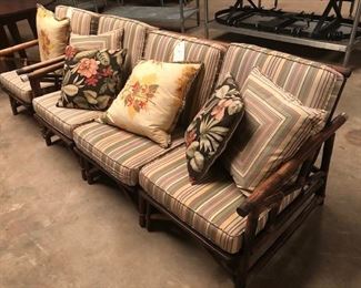 vintage rattan sofa and chair with pillows. There are 2 matching end tables and a mirror as well