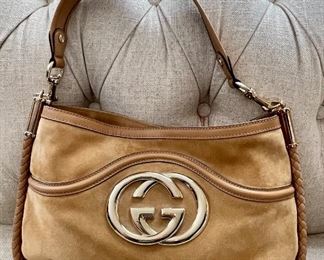 Item 161:  Gucci beige medium 'Britt' suede and leather shoulder bag with gold 'GG' hardware in front and braided trim along edge: $425