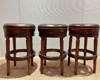 Item 239:  (3) Frontgate "Chapman" Bar Stools- solid hardwood, 180 degree swivel, carved detailing along the fluted legs and apron and hand-applied nailhead trim around the cushioned seat - 18" x 30": $650 for 3