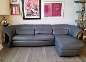 Amazing Grey Italian Leather Sofa by Kelvin Giormani. Truly stunning piece of furniture that was recently purchased and in excellent condition! The sofa measures 120" wide and the chaise is 66" deep. Please note that winning bidder is responsible for providing their own assistance moving this item and the pickup is at a different location.