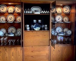 Lighted display cabinet full of Noritake stoneware sailboat dishes and glassware