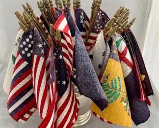 $50 - Vintage collection of 48 miniature cloth flags, each attached to gold plastic poles. The set was obtained as a promotion from grocery stores in 1976 to celebrate the USA bicentennial; set is sold without vase container.
