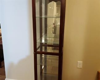 Slim lighted curio cabinet in a cherry finish. Cabinet has 4 glass shelves. Could not get light to work, may just need a new bulb. 20x16x72" Glass shelves 12x14 and are routed to hold plates. https://ctbids.com/#!/description/share/768266