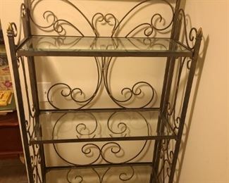Pretty metal bakers rack with four glass shelves. Leaf and vine design flows across the top piece. The shelf is painted metallic grey and gold colors. Measures 30" x 12" x 71".

https://ctbids.com/#!/description/share/768286