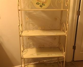 Shelf frame is made of metal and painted a cream color. Shelves and round decorative piece are made from wood. Shelves can be pushed up and sides pushed in so you can easily move the piece. Measures 28" x 13" x 61".

https://ctbids.com/#!/description/share/768214