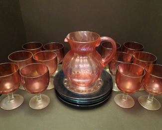 Set of 12 heavy purple glass goblets with clear stems are 6" tall. Pitcher is 8" tall, it is plastic but it matches the set nicely. 4 plates have the blue shimmer of carnival glass and are 10".

https://ctbids.com/#!/description/share/768249