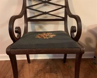 This is an Antique looking wooden chair with decorative scroll woodwork and artistic flourishes throughout, there is a floral design done in needlepoint on the seat cushion. There are signs of wear in the legs and arm surfaces. The back spine has some damage and splitting present. 22x20x34

https://ctbids.com/#!/description/share/768317