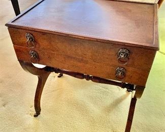 $350; Mahogany end table with lion ring pulls,; raised on brass capped feet and casters; 23" H x 20.5" W x 14" D