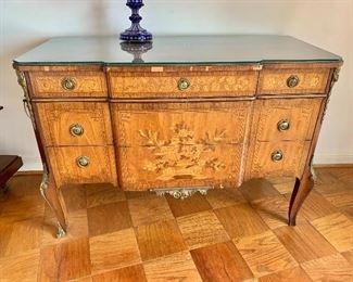 $800 - Louis XV Style 5 drawer commode with safety glass top. Parquetry and marquetry/inlay. Brass ring pulls and mounts; Inlaid dresser; light wear due to use and age, please note veneer loss. Bottom right ormolu missing from leg - 35" H x 50.5" W x 23" D