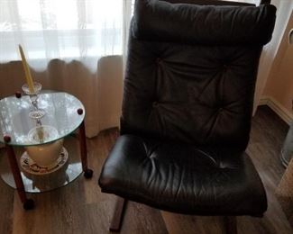 Black leather chair and glass side table.