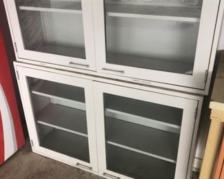 2 Stackable Glass Door Cabinets. Top has 1 adjustable shelf and bottom has 2 adjustable shelves.