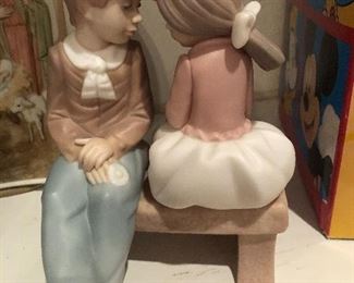 Pretty girl and boy figurine on bench