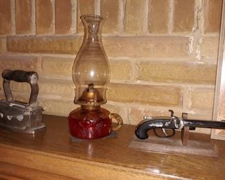 Antique coal iron, kerosene hurricane lamp and decorative pistol