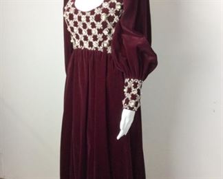 Lot	101	Stunning Shakespeare Inspired Burgundy Gown	Burgundy Velvet Long Sleeve Full Length Gown Top portion of gown adorned with "Jewels" of Pearls, Rhinestones & Beading Front & Back Zipper Cuffs note - Cuffs matching Jewel Pattern Zipper Back - Satin Lined Labeled Size 8
