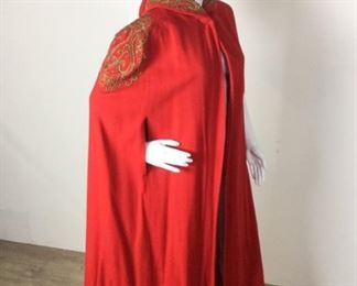 Lot	114	Vintage Red Wool Ornate Hooded Cape	Vintage Red Wool Ornate Hooded Cape Golden Thread & Seed Beads - Floor Length Lined Long Cape "Little Red Riding Hood" approves of this Dramatic Cape Custom Creation - - *** NO SIZING *** Some Separation of lining and shell at arm holes (educated guess women's 8-10)
