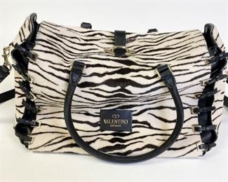 Lot	202	Valentino Garavani Leather and Zebra Purse	Authentic Valentino leather and zebra pony style calfskin satchel with buckles on the sides, silver tone hardware, removable leather shoulder strap, no marks or tears, bag appears to have been barely used. 14.5" l x 10" h x 6" w
