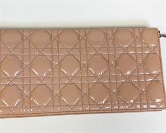 Lot	228	Pink Christian Dior Small Quilted Clutch	Christian Dior clutch crafted of geometric quilted patent leather in pink. with polished silver Dior letters charm at the clasp. Facing flap opens to a grey grosgrain and matte leather interior with a card slot panel and a full zipper compartment, pen marks on the inside and some staining on interior 10.5" l x 5" w x 1" d
