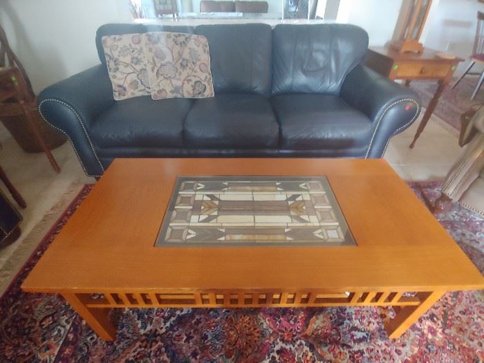 Navy Blue Leather Sofa with stud accents and Mission Style Coffee Table with Stained Glass Insert.  Karastan Rug