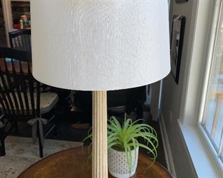 Lot 5508  $44.00. 30" H  Columnar Table Lamp in a Textured Cream Color Furnish. 15" Diameter Shade. Paired with a Faux plant in Pottery Pot.