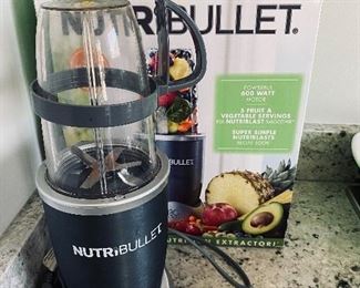 Lot 5540. $26.00 Nutribullet set with box, includes; power base, short cup with a handled ring, tall cup, extractor blade, 1 lip ring, and a care booklet.